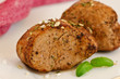 Roasted slices of pork fillet on a plate seasoned with herbs
