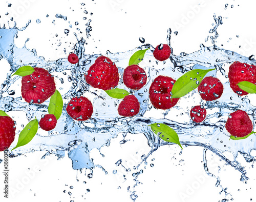 Fototapeta do kuchni Fresh raspberries in water splash, isolated on white background