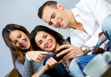 Three Friends Having Fun With A Mobile Phone