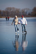 © lightpoet - Couple ice skating outdoors on a pond on a lovely winter day