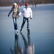 © lightpoet - Couple ice skating outdoors on a pond on a lovely winter day