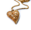 Golden pedant in the shape of a heart on the white background