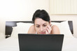 © dacasdo - beautiful girl relaxing on the bed with her laptop
