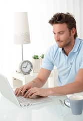 Canvas Print - Handsome man typing on laptop computer