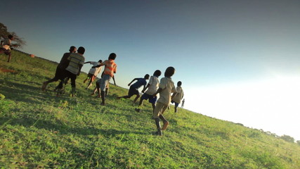 african youth playing soccer on the fields in kenya.