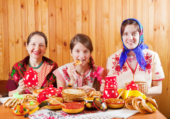 Women eats pancake  during  Shrovetide