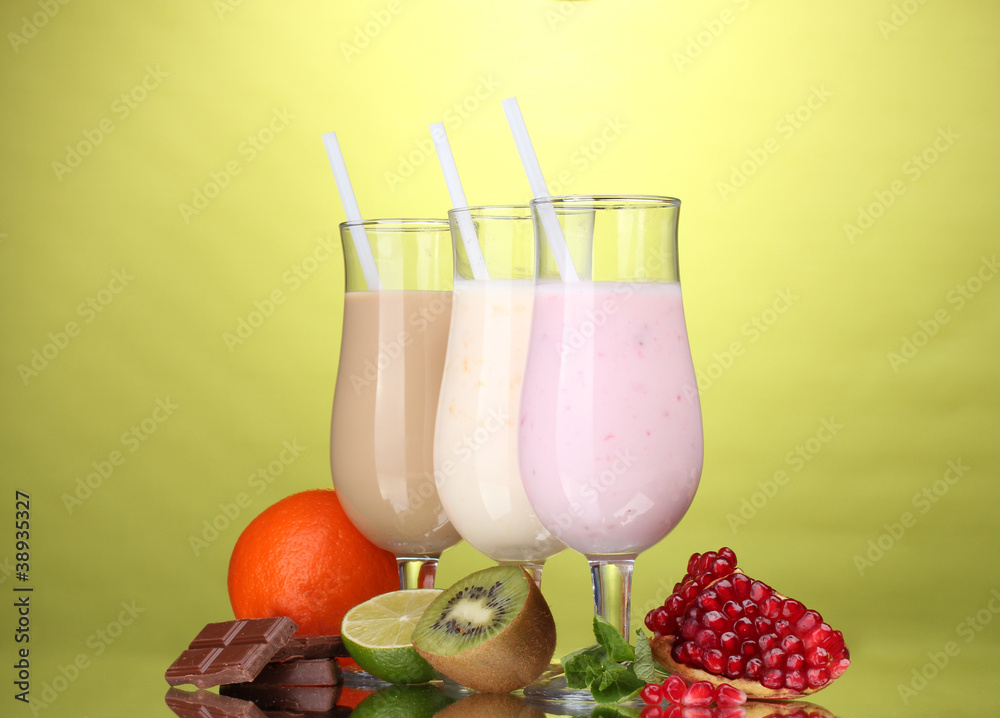 Milk shakes with fruits and chocolate on green background