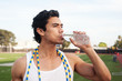 Handsome, young latino athlete drinking water