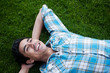 Happy young man lying in grass