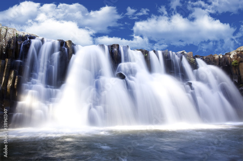 piekny-watterfall-z-jasnym-niebieskim-niebem-w-tle