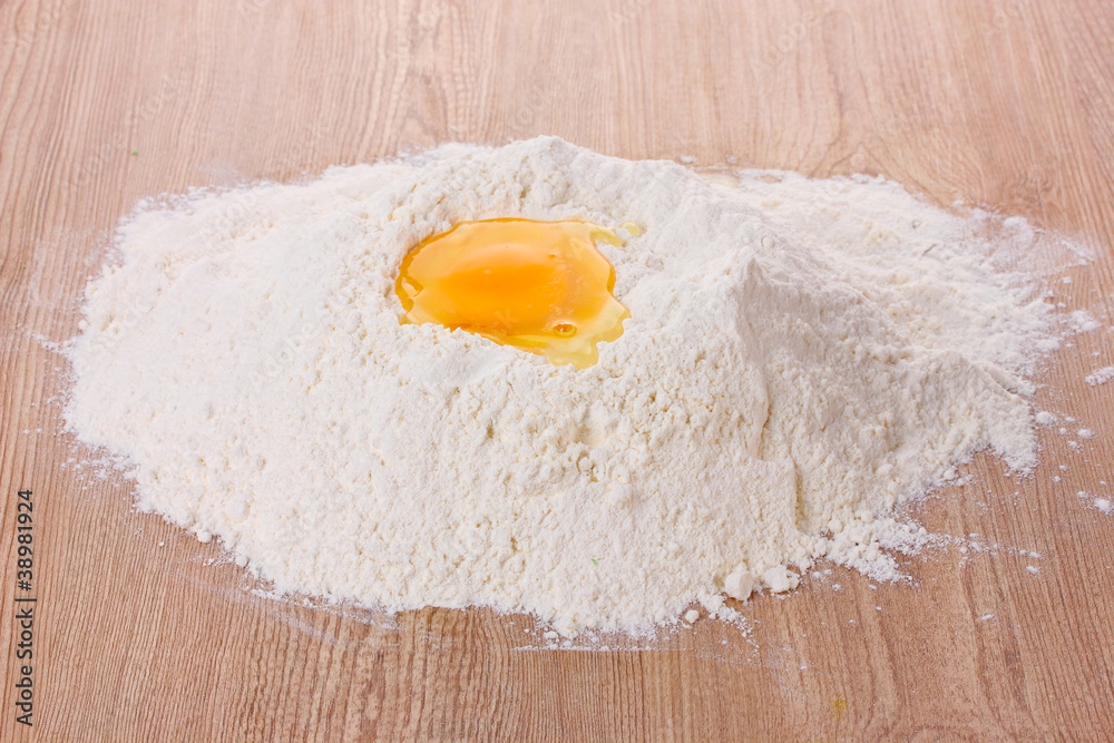 egg in flour on wooden table