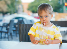 Portrait Of Adorable Little Boy Drinking Juice