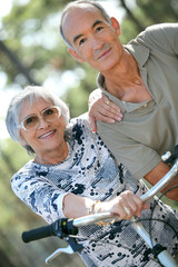 Wall Mural - Older couple riding bikes in the countryside