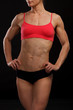 © Nobilior - Muscular female body against black background