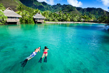 Young Couple Snorkeling In Clean Water Over Coral