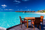 Fototapeta Do akwarium - Table and chairs at beach restaurant