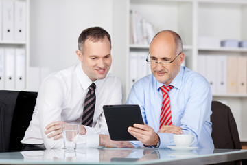 Poster - zwei geschäftsmänner schauen auf den tablet-pc