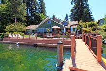 Lakefront Green One Story House With Dock And Large Deck.