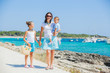 © Max Topchii - Family of three walking along tropical beach