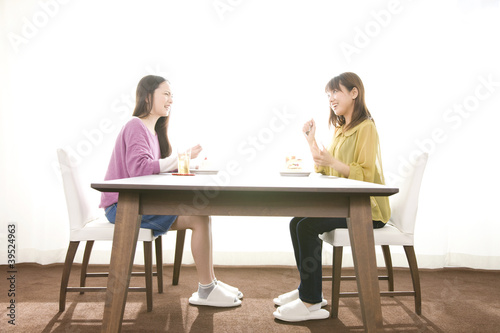ダイニングでケーキを食べる女性2人 Stock Photo Adobe Stock