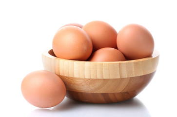 brown eggs in wooden bowl isolated on white