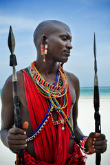 maasai sitting by the ocean on the beach