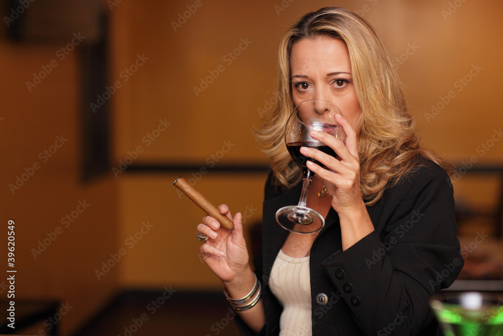 Woman drinking wine and smoking a cigar Stock Photo