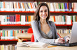 © stokkete - Young woman with his laptop computer at the library.