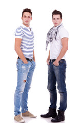 two friends standing with their hands in pockets