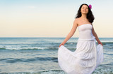 Fototapeta Na drzwi - The woman in a white sundress on seacoast.