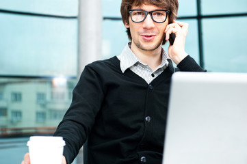 Friendly executive sitting in front of laptop in his office.