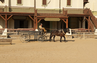 Fototapete - Cowboy driving a wagon at Mini Hollywood Movie Set , Spain
