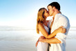 © Daxiao Productions - Newlywed couple kissing on honeymoon intimate moment.