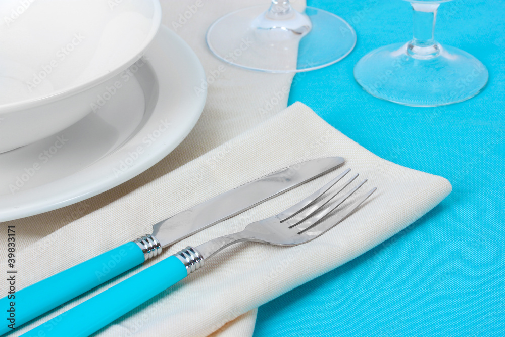 Table setting with fork, knife, plates, and napkin