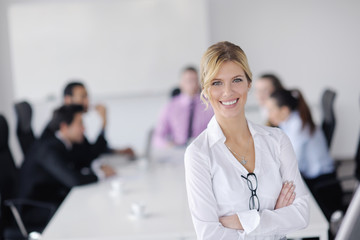 Wall Mural - business woman standing with her staff in background