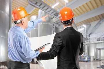 Team of construction workers with orange helmets at work place i