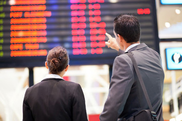 businessman and businesswoman checking flight information