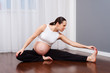 © ArtFamily - pregnant woman doing gymnastic at home