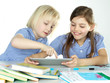 © Karin & Uwe Annas - Two cute girlfriends learning with books and touchpad