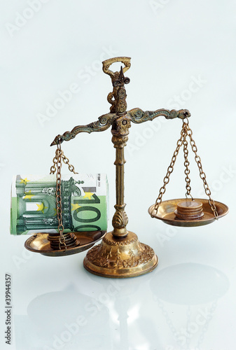 Geld auf der Waage Stock-Foto | Adobe Stock