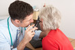 © Monkey Business - British doctor examining senior woman's ear