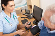 © Monkey Business - British nurse taking senior man's blood pressure