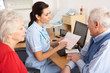 © Monkey Business - British nurse talking to senior couple