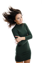 Model in green dress flinging long hair into air.