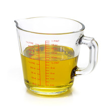 Oil in measuring cup isolated on white background