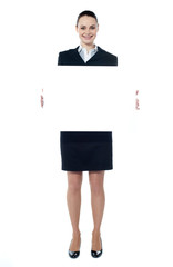 Caucasian businesswoman holding a blank billboard