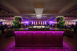 wooden bar counter with pink illumination in large restaurant