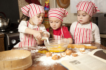 Wall Mural - Three little chefs enjoying in the kitchen making big mess. Litt