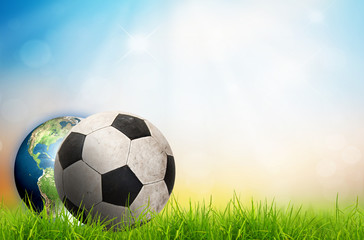 soccer ball and earth on green grass