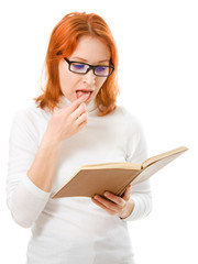 Beautiful red-haired girl in glasses reads book.